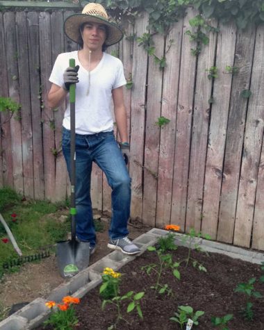Allen Dishigrikyan next to some newly planted marigolds, tomatoes, cucumbers and peppers.